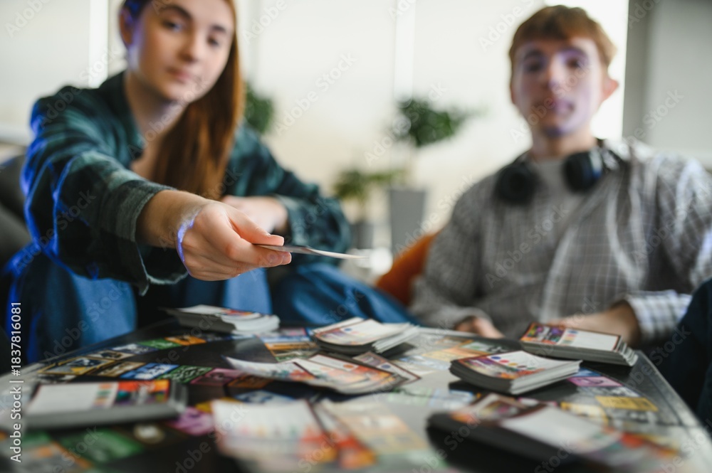 Fototapeta premium Friends playing card game at home, choosing strategy, having fun