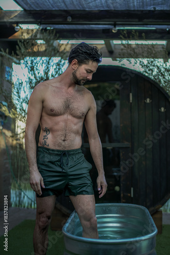 Hombre jóven entrando al baño frio después de usar la sauna