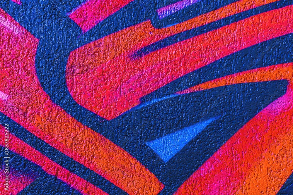 Naklejka premium Graffiti art in bright orange, blue, red with textured surface. 90s urban style, vibrant colors, dynamic lines. Street art, murals, modern 90s, urban visuals, creative design.