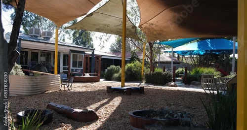 Outdoor kindergarten playground shaded by fabric sun sails in an Australian early childhood education center. Concept of sun protection, UV safety, outdoor learning environment, community childcare