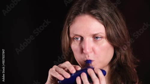 Young woman playing blue ancient ocarina. Musician performing traditional ceramic wind instrument. Musical art and culture concept.