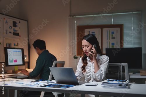 Asian businesswoman working late night and talking on phone