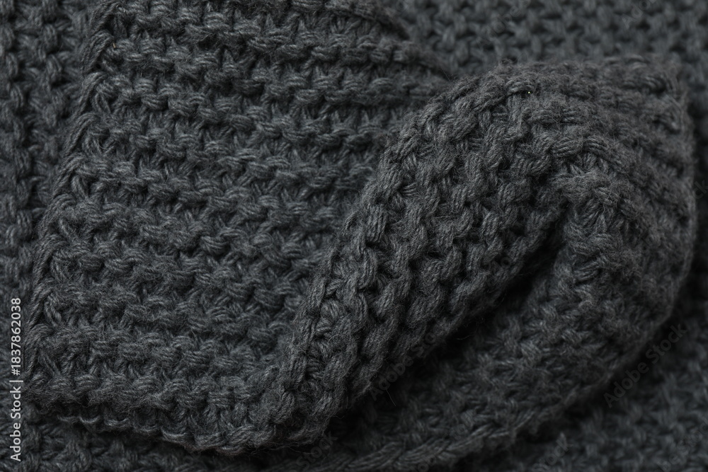 Fototapeta premium Texture of gray knitted fabric. Macro photography of natural wool background. 