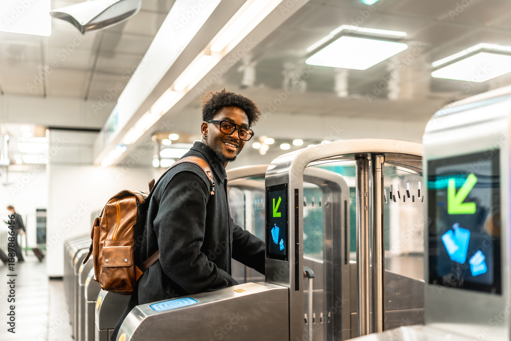 Naklejka premium Smiling man passing subway station ticket gate