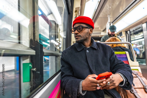 Man in red beanie commuting on public transport checking phone