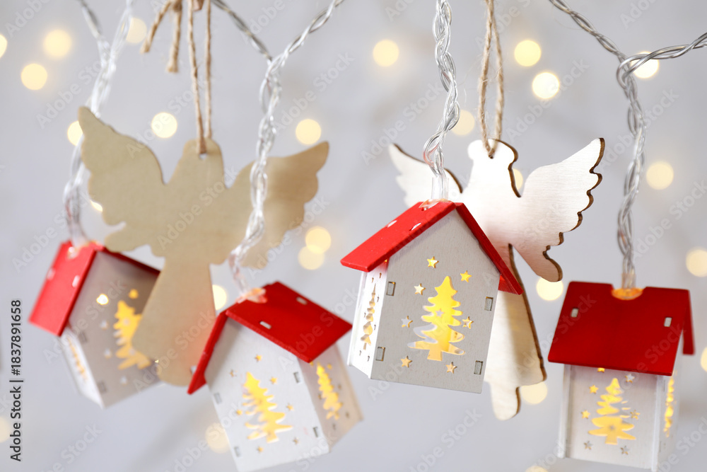 Obraz premium Different Christmas decor hanging against grey background with blurred lights, closeup. New Year greeting card