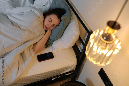 Woman peacefully sleeping in a bedroom at night with soft lighting