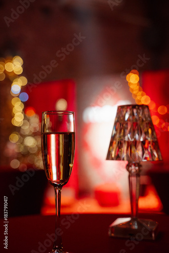 Elegant champagne glass with sparkling drink on table in festive atmosphere with lights