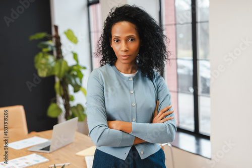 Foto Confident Black businesswoman crossing arms, standing in corporate office