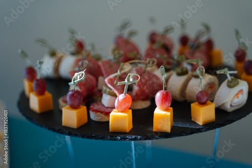 Assorted gourmet appetizers on a black platter with vibrant colors and elegant presentation
