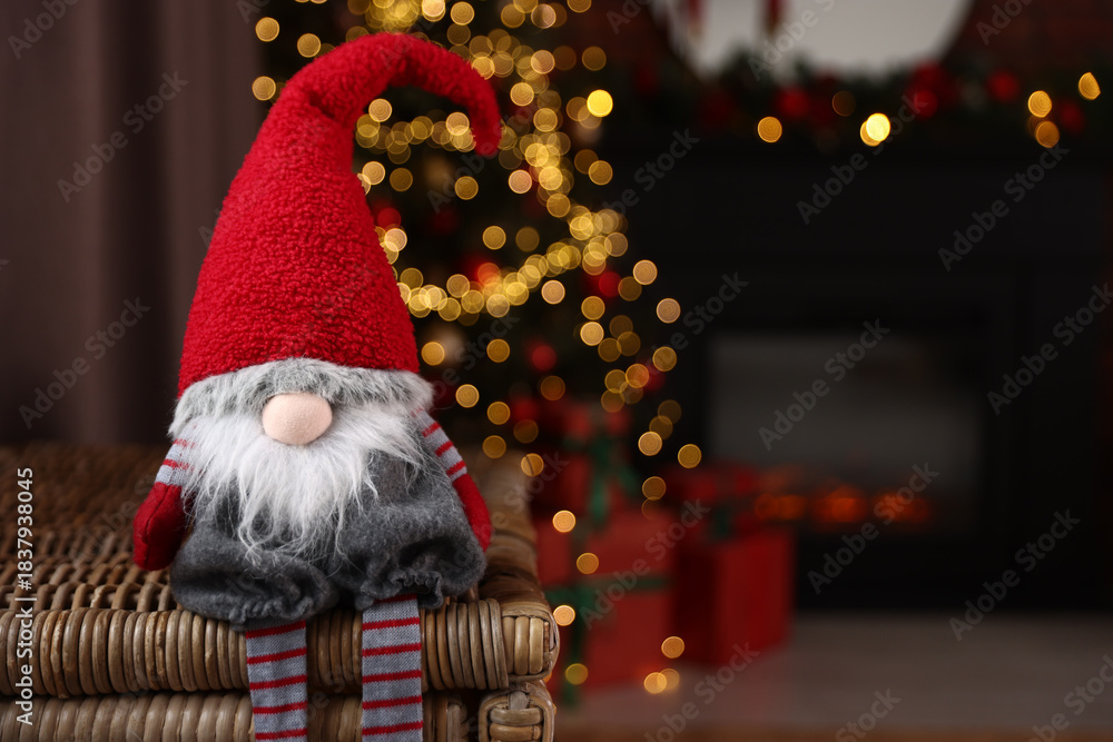 Fototapeta premium Funny Christmas gnome in decorated room, closeup. Space for text