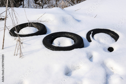 Old car tires in a snowdrift