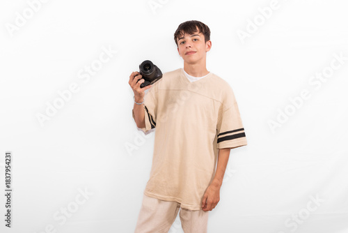 young photographer casual dressed Generation Z white male model fun teenage boy photo with DSLR camera. happy smile expressing joy in positive entertaining way in plain background studio setting