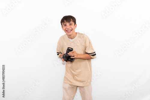young photographer casual dressed Generation Z white male model fun teenage boy photo with DSLR camera. happy smile expressing joy in positive entertaining way in plain background studio setting