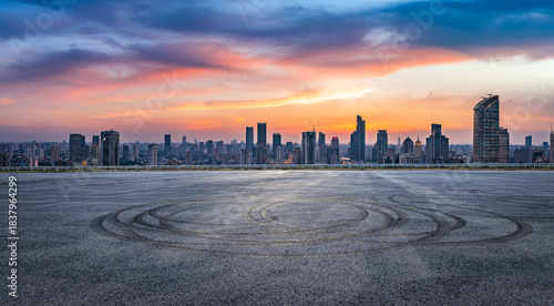 Empty asphalt road and city skyline with modern buildings at sunset in Shanghai