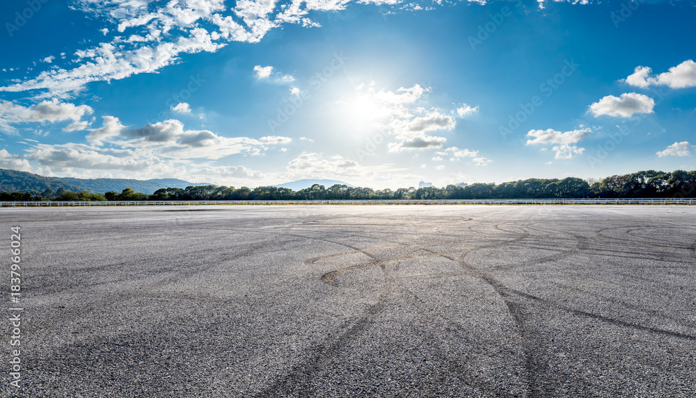 Fototapeta premium Asphalt race track road and tire track with dramatic sky clouds background