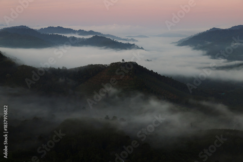 sea of mist and mountain landscape at sunrise. Foggy valleys and rolling hills during dawn in Southern Thailand.