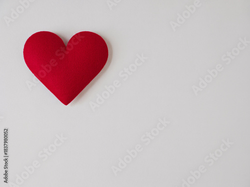 Wallpaper Mural A vibrant red heart-shaped pillow rests gently on a clean, minimalist white background, symbolizing love and affection. Torontodigital.ca