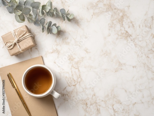 Cozy flat lay on marble with tea, notebook, and gift box for a relaxing moment