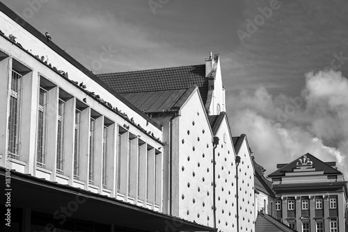 facade of a modern building and a historic tenement house on the Old Market Square in Poznan