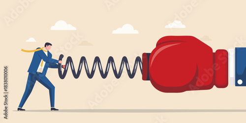 Business person struggles against a large red boxing glove on a spring