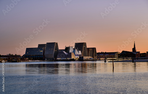 Papirøen or Papiroen sunset, new waterfront district in Copenhagen. Contemporary angular buildings mirrored in calm harbour water showcase cutting edge Nordic architecture and modern urban lifestyle