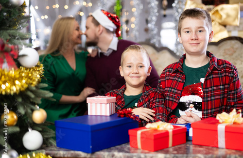Children and parents give each other gift boxes during Christmas or New Year celebrations at home