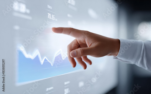 Male hand touching virtual screen showing financial graph for analyzing stock market trends and business investment growth with focused determination