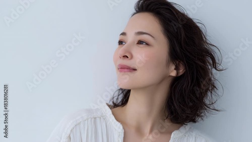 Young woman portrait face gaze soft light calm expression looking upward with soft smile natural light serene expression loose wavy hair smiling