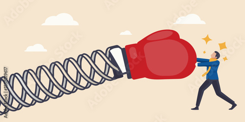 A businessman struggles to push a large boxing glove on a spring