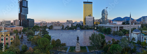 Aerial panorama of Skanderbeg Square at Dawn surrounded by modern towers and city landmarks.