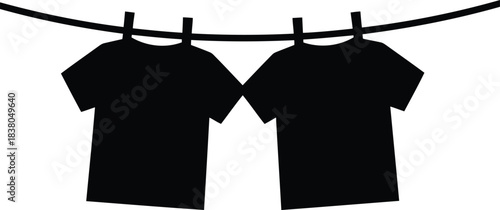 Two black t shirts hanging on a clothesline clothing