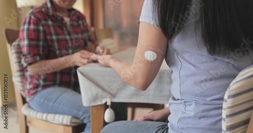 Asian mother makes blood glycemia test to her daughter for diabetes check at home - Family disease, medicine and lifestyle concept