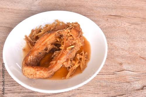 deep fried chop red Tilapia or mango fish slice dressing soy sauce and celery on plate 