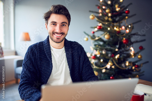 Portrait of young freelancer working at home during Christmas season