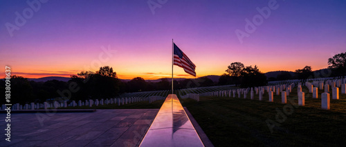 Sunset over cemetery with American flag and headstones in view
