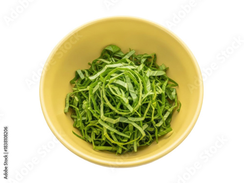 Isolated image of freshly chopped green cabbage leaves in a yellow bowl, ready for cooking