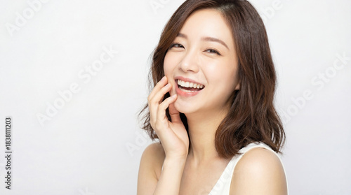 Happy asian woman smiling touching her face
