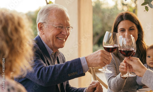Senior man smiling and toasting wine glass outdoors