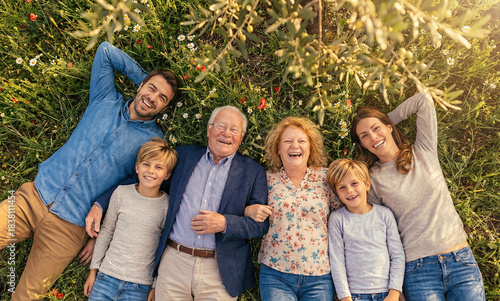 Happy family relax lying on grass, top view