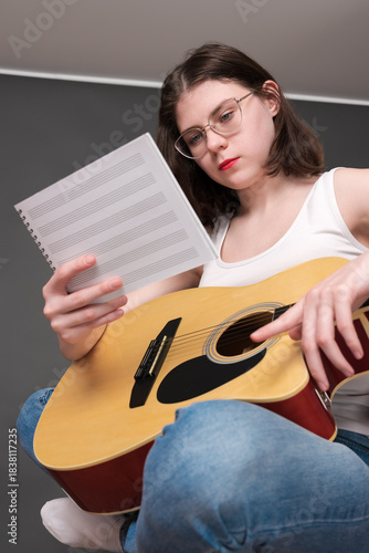 Canvas Print Woman musician holds sheet music, deciphering and analyzing new musical creation