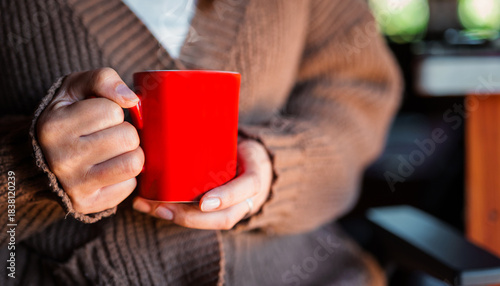 Woman Holding Hot Coffee Cup in Cozy Knit Sweater, Winter Warmth Concept