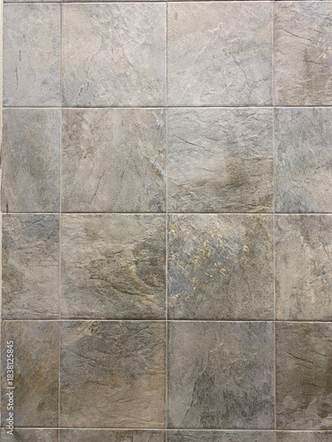 Gray stone-effect floor tiles in a grid pattern with natural texture and subtle brown and beige variations