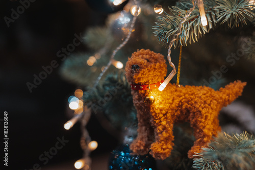 Cozy Christmas tree ornament with a handmade plush dog, glowing fairy lights and warm festive bokeh. Perfect for New Year 2026 ambience, holiday decor concepts, seasonal celebration design projects.