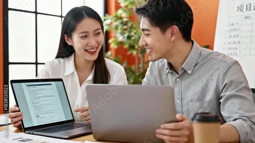 Wallpaper Mural Smiling young female colleague discussing project ideas with handsome male colleague while working on laptop in office Torontodigital.ca