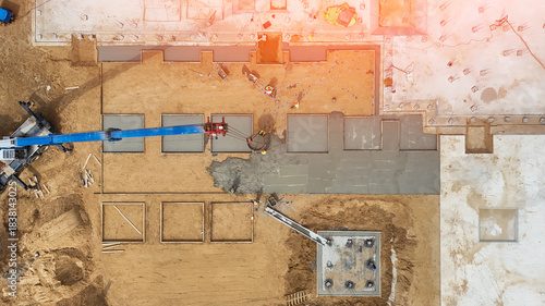 Construction of the foundation of a residential building top view. Monolithic foundation. An automobile crane is used to pour concrete onto the foundation of a building under construction. High qualit