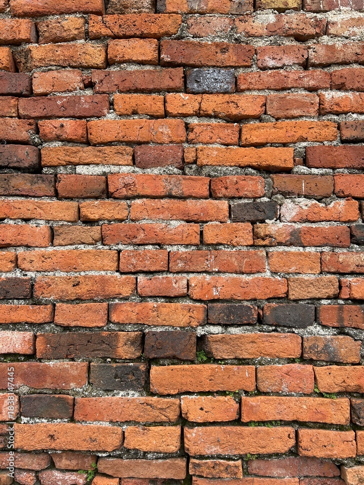 Obraz premium Old brick wall in Thailand, ruins of an old temple, bricks blackened by moisture