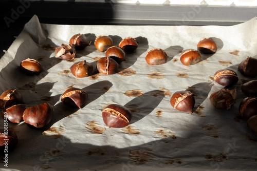 Roasted chestnuts on parchment paper close-up, homemade