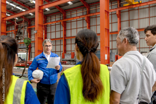 Supervisor of diverse engineers briefing his team before working in manufacturing factory. Leader giving a briefing to team in industrial site. Worker manager conducting a site meeting in a factory.