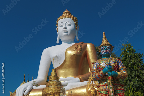 Foto Chiang Mai, Thailand - November 23 2025 : A large white and gold sitting Buddha statue during afternoon at Wat Phra That Doi Kham, Chiang Mai